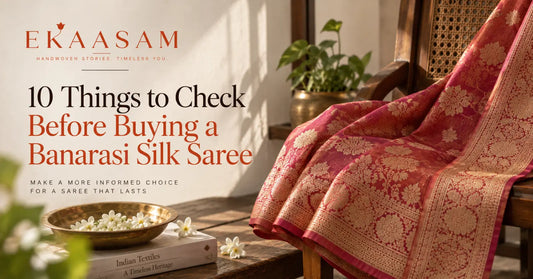Red Banarasi silk saree with intricate gold floral zari work draped elegantly in a traditional interior setting.