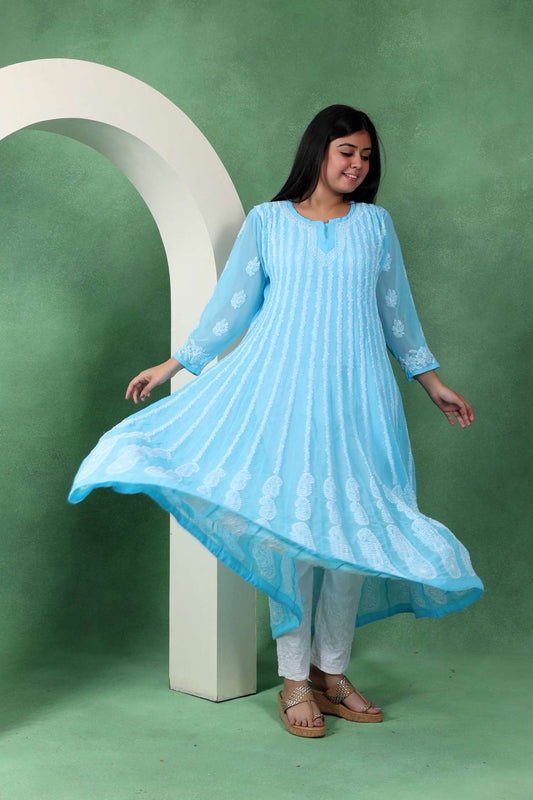 Woman wearing a light blue dress with white patterns on a green background